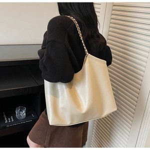 Detail of soft cream leather tote with textured wrinkles and elegant chain strap