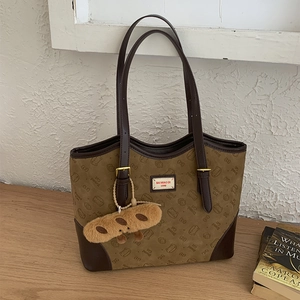 Detail of vintage tote bag with Bread Cat print and red label on wooden surface