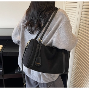 Grande borsa a spalla nera opaca con manici in pelle e dettaglio del ciondolo brand