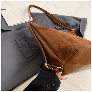 Detailed macro of brown suede and smooth leather stitching on stylish hobo bag