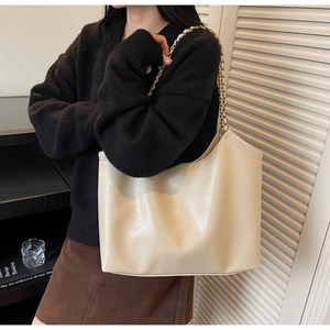 Detailed view of cream tote bag with elegant chain strap and textured leather finish