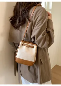 Detail of minimalist bucket bag with cream pleated leather and brown trim on model