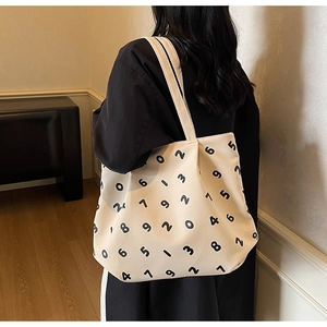 Detail of minimalist canvas tote bag featuring black numeric prints on cream white fabric