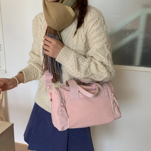 Borsa tote in nylon rosa pallido indossata con maglieria per un look autunnale casuale