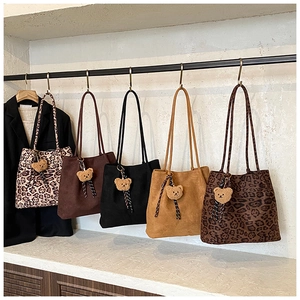 Detail view of large tote bags in leopard print and solid colors with plush bear charms