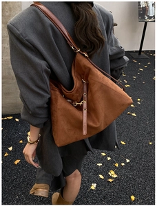 Dettaglio della borsa tote in pelle scamosciata marrone con cinturini in pelle e fibbia