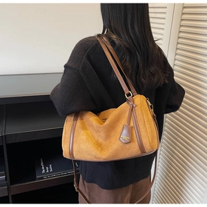 Dettaglio della borsa vintage in pelle scamosciata con manici marroni e targhetta