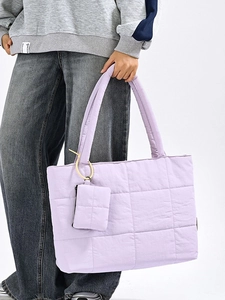 Light purple quilted tote bag with matching coin purse shown on casual model