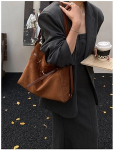 Dettaglio della borsa tote in pelle scamosciata caramello con finiture in pelle scura