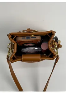 Top view of caramel brown bucket bag showing interior storage for phone and lipstick