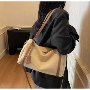 Dettaglio della borsa beige opaco con finiture in pelle marrone e zip in metallo oro