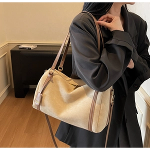 Modella con borsa hobo grande beige in nabuk e cinturini in pelle marrone autunno