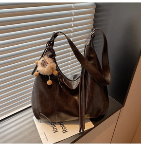 Detailed view of coffee brown retro tote bag with tassel fringe and plush lamb charm