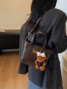Retro dark brown bucket bag with gold metal logo and cute plush bear charm for women