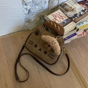 Détail du sac chat marron mignon avec son accessoire de charme en peluche de pain
