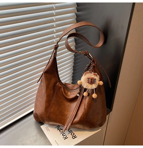 Brown vintage hobo bag with adjustable strap and cute plush sheep charm detail