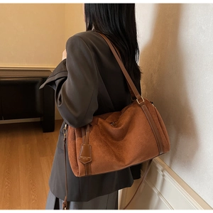 Vista dettagliata della borsa a spalla in pelle scamosciata marrone con logo