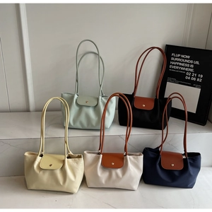 Detailed close-up showing five color variants of textured nylon tote bags on display
