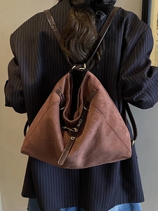 Zaino minimalista marrone caffè in pelle scamosciata con spalline su modella in blazer