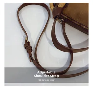 Detail of adjustable leather strap with metal buckle on dark brown shoulder bag