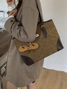 Retro brown suede tote bag with Bread Cat print and plush charm shown on a model