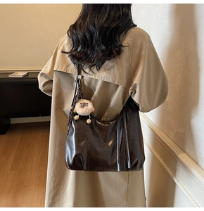 Detail of vintage coffee brown leather hobo bag with cute sheep charm accessory