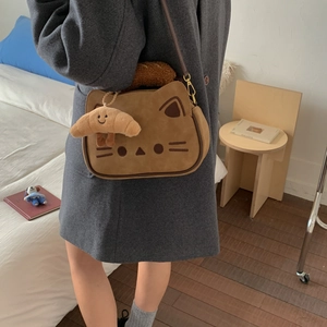 Vue détaillée du joli sac bandoulière chat marron avec pendentif croissant en peluche sur manteau