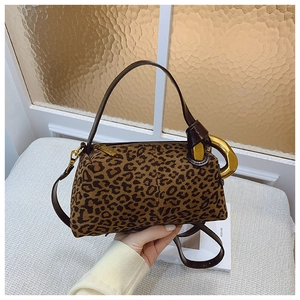 Detail of leopard print barrel bag with brown leather strap and gold horseshoe hardware
