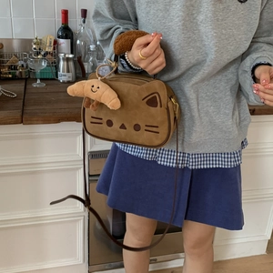 Détail d'un joli sac à main chat marron avec breloque croissant et visage brodé