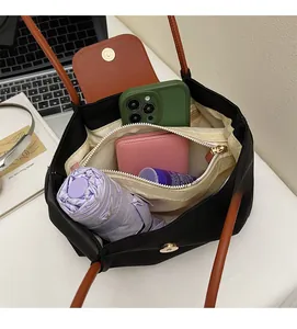 Internal view of a black nylon tote bag showing compartments, laptop, and daily essentials