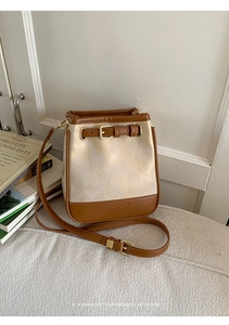 Detail of contrast stitching and embossed leather branding on vintage bucket bag