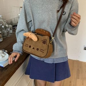 Vue détaillée d'un sac bandoulière marron en forme de chat porté par un mannequin femme