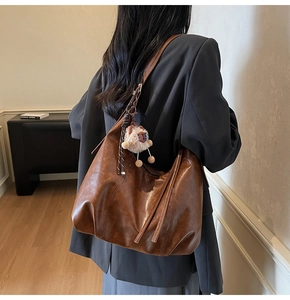 Braune Hobo-Tasche aus Leder mit stilvollen Fransen und einem Plüschschaf-Anhänger