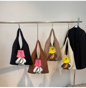 Row of four knitted tote bags with cartoon bear embroidery in neutral colors