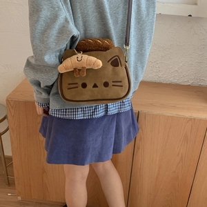 Détail d'un sac à bandoulière chat marron mignon avec un pendentif croissant en peluche