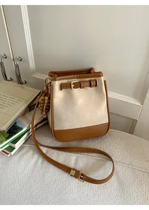 Detail of color-block bucket bag with pleated texture and adjustable strap