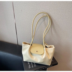 Close-up of cream beige pleated shoulder bag with long strap and snap button closure