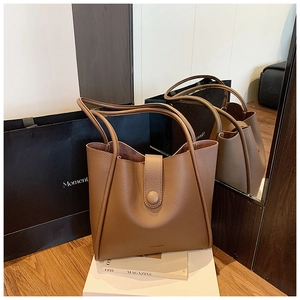 Detailed close-up of brown litchi pattern synthetic leather tote with magnetic buckle