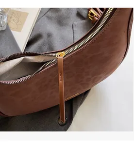 Detail of vintage leopard print crescent bag with smooth zipper and golden hardware