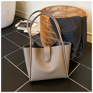 Detailed close-up of large taupe tote bag with pebble leather texture and HOCOMU logo
