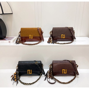 Detail view of four vintage flap bags with gold buckles and beaded tassels on display