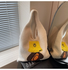 Detailed view of cream plush tote bag featuring a cute cartoon patch with yellow hat