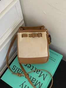 Minimalist patchwork bucket bag in beige and brown leather with adjustable shoulder strap