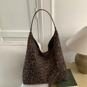 Leopard print tote bag with large capacity displayed on a cozy white fabric sofa