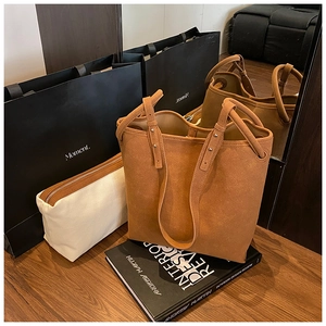 Große braune Schultertasche aus mattem Material mit stilvollen Metallnieten