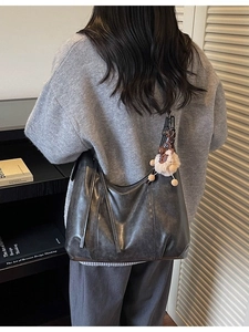 Vintage large capacity dark grey leather tote bag worn by a model in a lifestyle setting