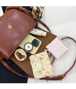 Brown vintage shoulder bag interior detail showing capacity for phone and cosmetics