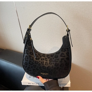 Detailed shot of black leopard print hobo bag with leather strap and golden hardware
