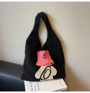 Close-up of black fuzzy tote bag featuring creative cartoon embroidery and plush texture