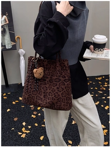 Detail of vintage leopard print tote bag with a cute brown plush bear charm accessory